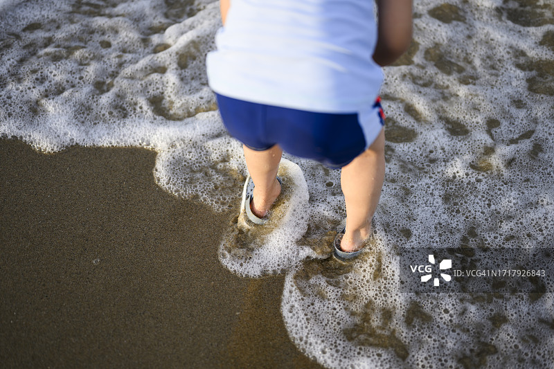 小男孩在日本福冈的海滩上玩耍图片素材