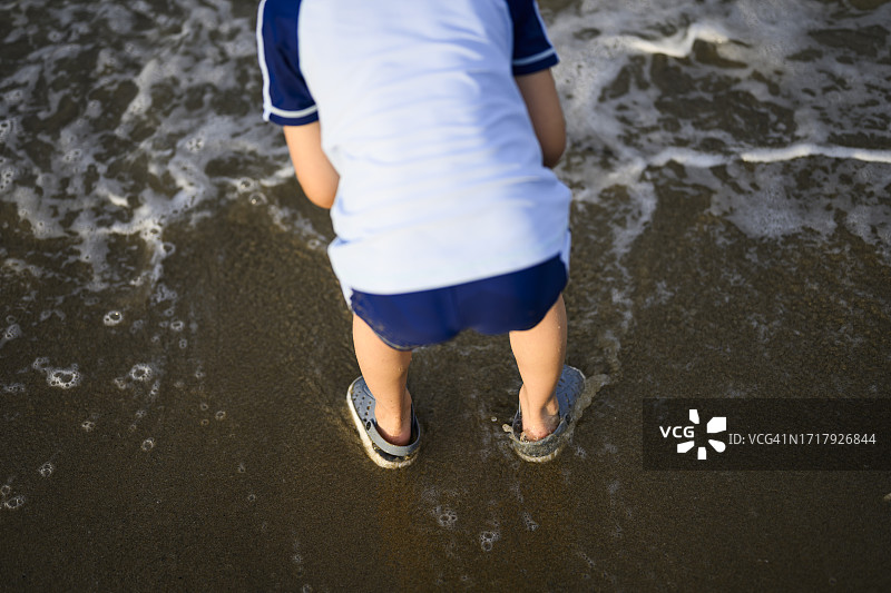 小男孩在日本福冈的海滩上玩耍图片素材