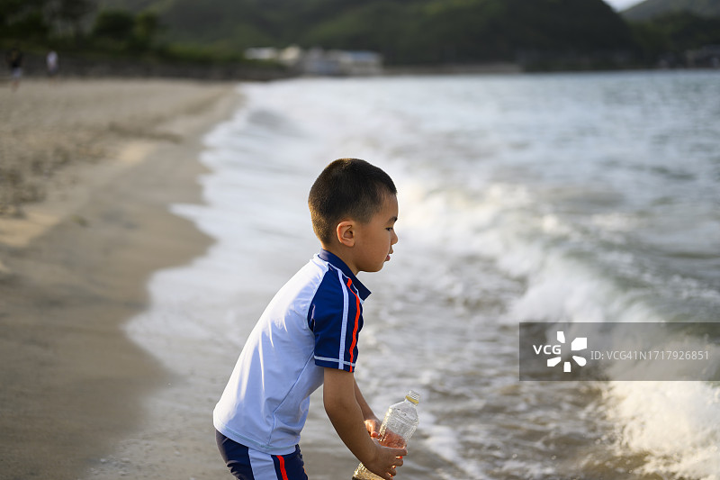小男孩在日本福冈的海滩上玩耍图片素材