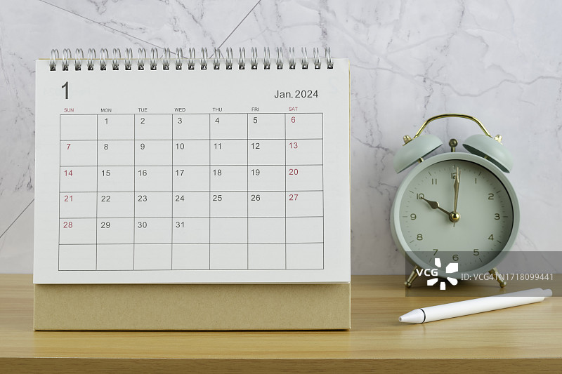 2024年台历：1月工作台上闹钟和白色笔日常工作生活计划图片素材