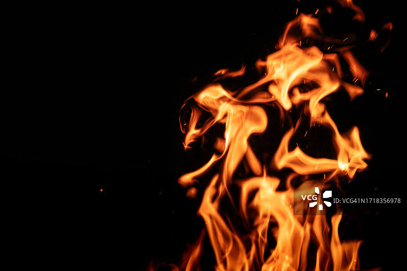 黑色背景上的燃烧火焰与火花图片素材