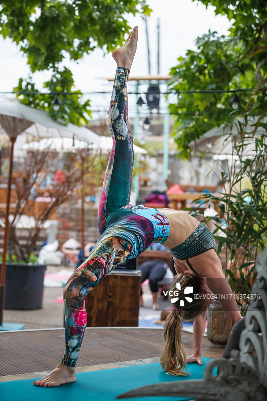 户外练习瑜伽的女人：单腿轮式图片素材