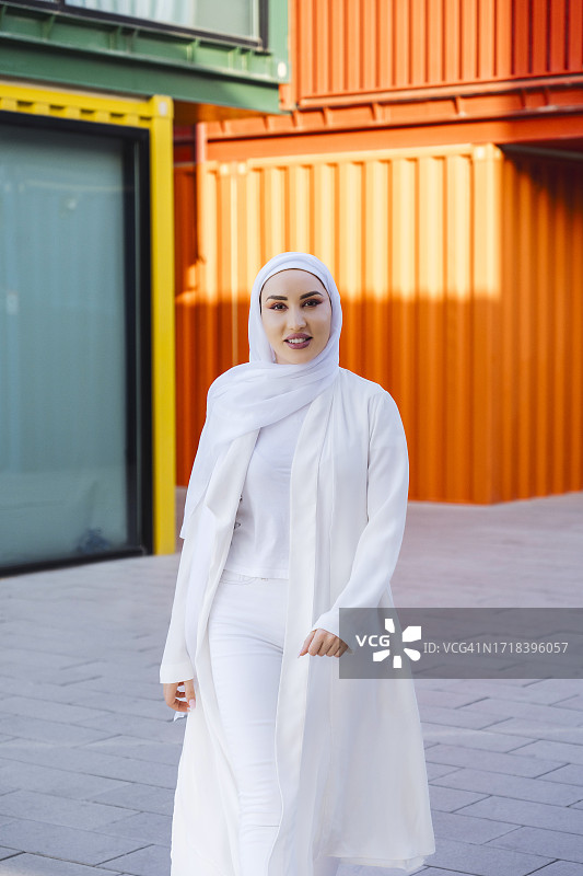 戴盖头的穆斯林妇女在街道上行走图片素材