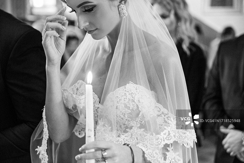 新娘在教堂用手中的蜡烛划十字图片素材