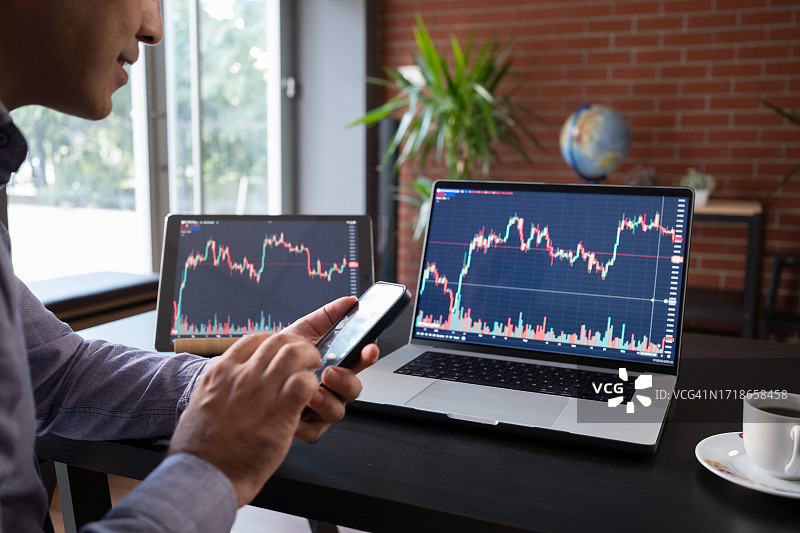 男人用笔记本电脑查看股市投资图片素材