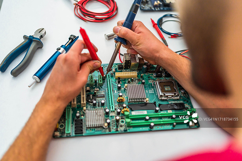 男子修理损坏的电脑主板图片素材