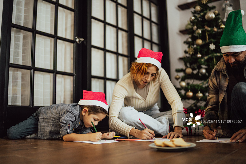 家庭在客厅地板上绘制圣诞画图片素材
