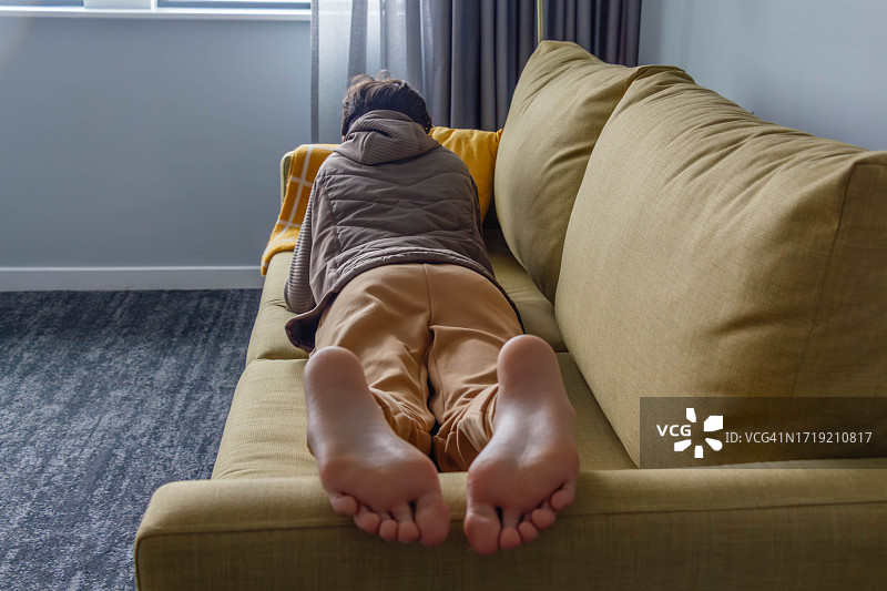 躺在沙发上的男孩的赤脚图片素材