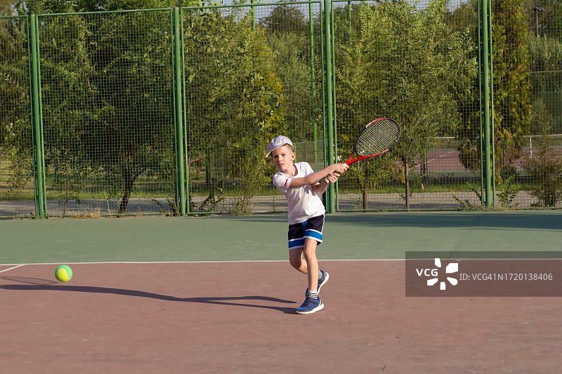 在户外打⽹球的左撇⼦⼩男孩图片素材