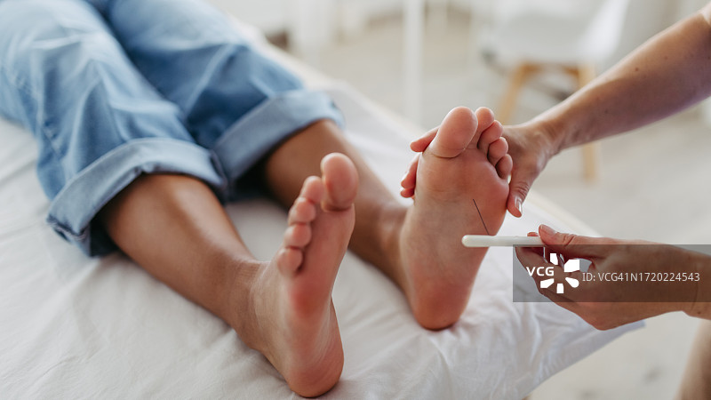 糖尿病专家正在测试患者足部的感觉丧失情况。图片素材