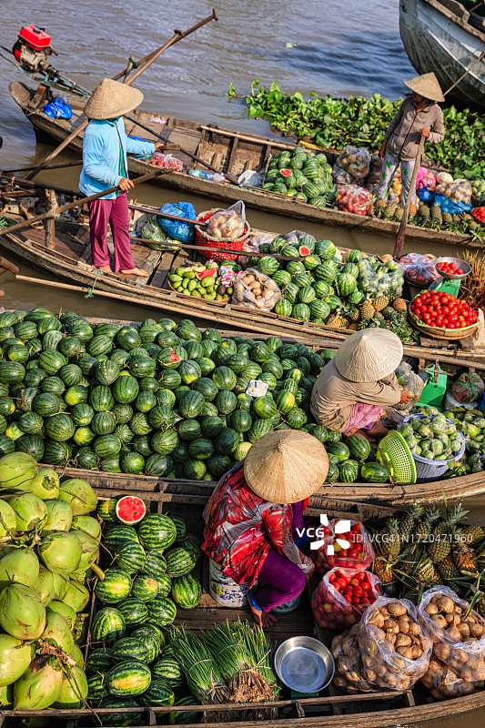 越南妇女在湄公河三角洲水上市场卖水果图片素材