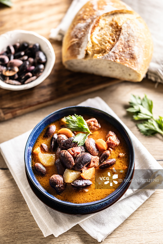 厨房桌子上蓝色碗里的美味豆汤图片素材