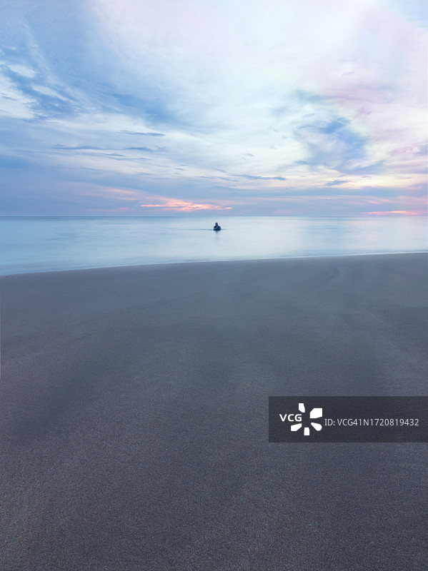 日落时分在海中游泳的女性剪影图片素材