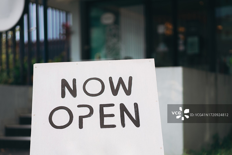透过门玻璃看到的营业中标志牌图片素材