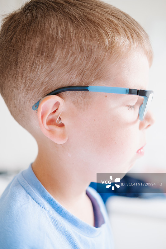 戴助听器眼镜的9岁男孩侧面像图片素材