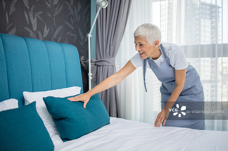 酒店客房服务员整理床铺图片素材