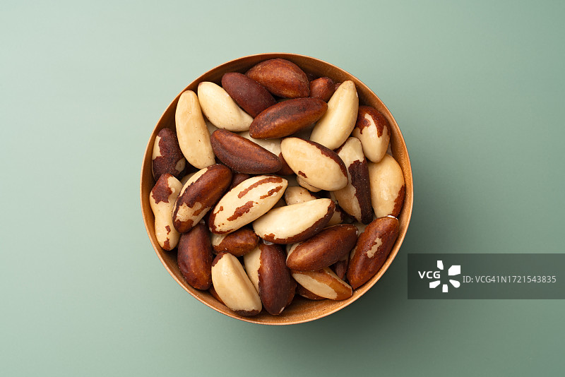 绿背景木碗中的巴西坚果图片素材