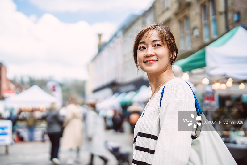 在小镇的周末市场里闲逛的年轻女游客图片素材