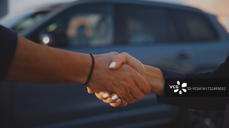 汽车销售员和顾客在经销店握手特写图片素材