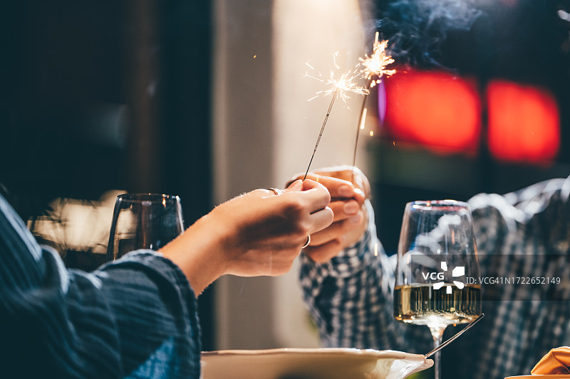 情侣在咖啡馆庆祝圣诞节并燃放烟花棒图片素材