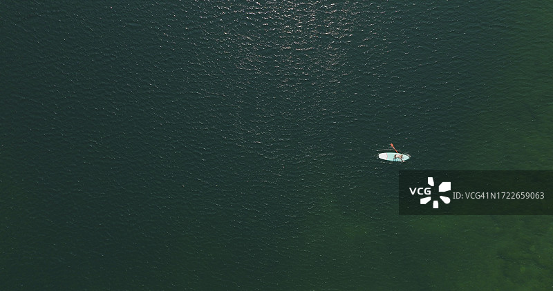 桨板爱好者在宁静的湖面上享受休闲时光鸟瞰图片素材