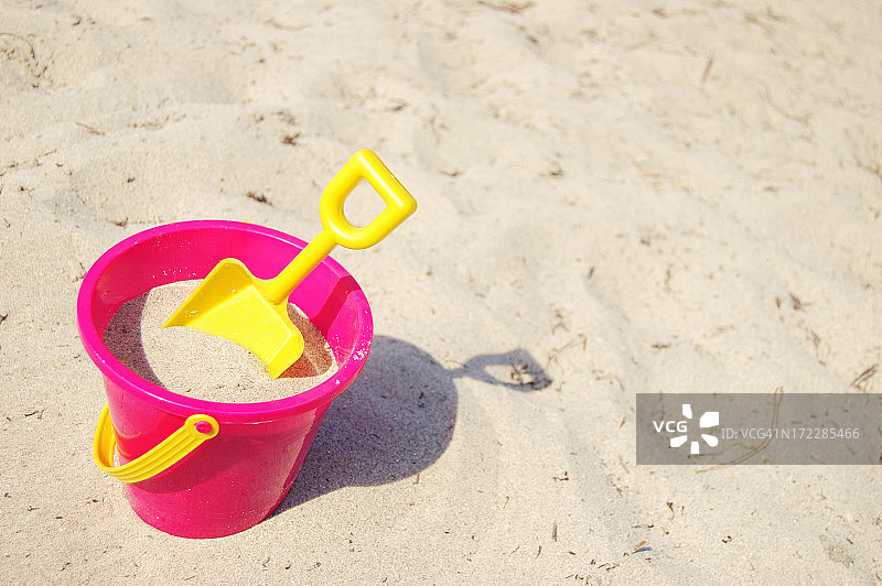 沙滩上的粉色桶和黄色铲子图片素材