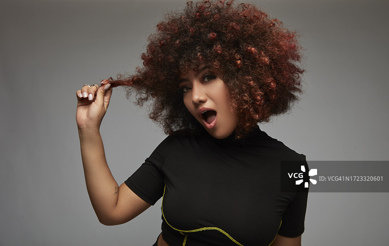 卷发混血年轻女人玩头发图片素材