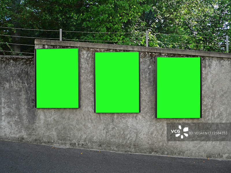瑞士洛桑公园灰色混凝土围墙上的三个矩形绿色空白广告牌图片素材