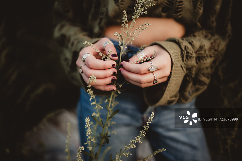 戴着手镯和戒指采花的少女图片素材