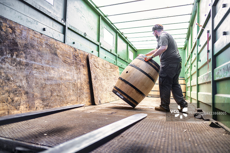 在赫雷斯（雪利酒产区）的桶匠将桶装上卡车，运送给苏格兰麦芽威士忌生产商图片素材