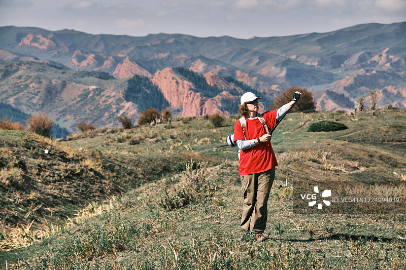 在山区徒步旅行并直播的活力中年妇女图片素材