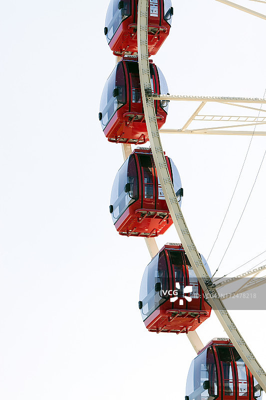 红色车厢的摩天轮特写，白色背景，留白图片素材