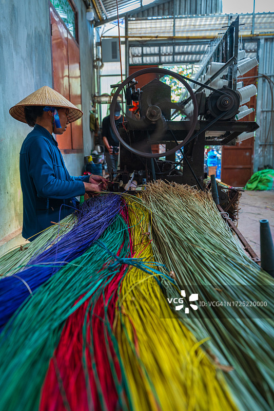 女人在织机上编织莎草垫图片素材