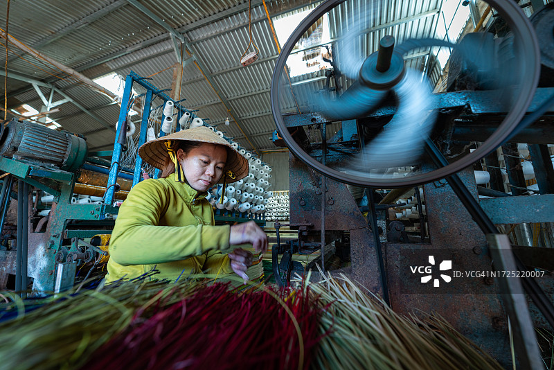 女人在织机上编织莎草垫图片素材