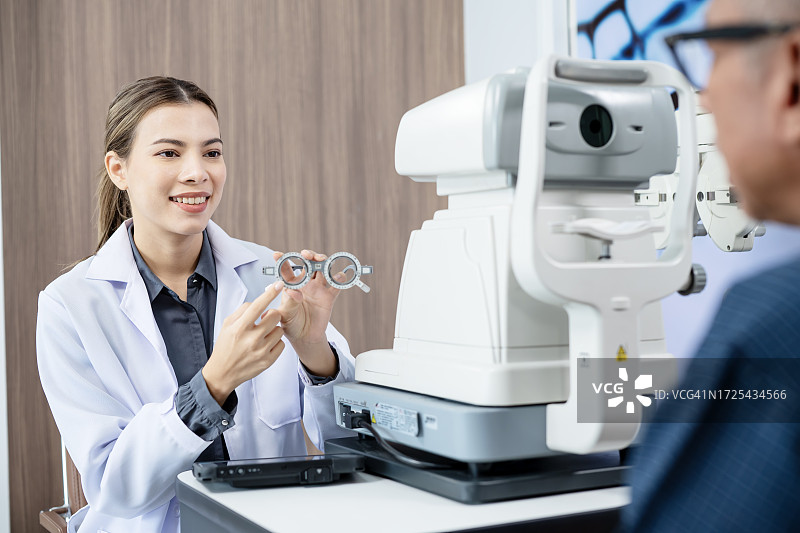 通过常规眼科检查改善视力的眼镜。女眼科医生在眼科诊所用试镜架为老年男性患者进行眼科检查。图片素材