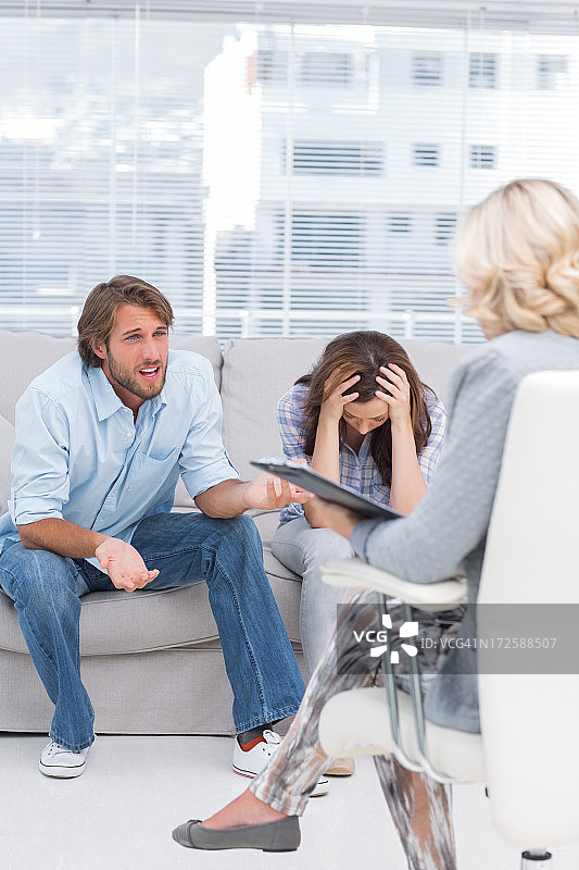 理疗师倾听坐在沙发上的夫妇图片素材