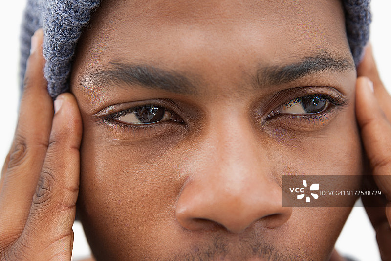 戴着无檐小便帽看起来沮丧的男人图片素材