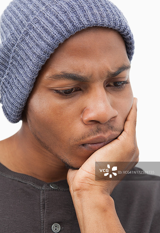 戴着无檐小便帽，若有所思的男人图片素材