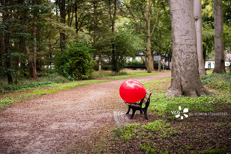 德国杜塞尔多夫公园长椅上的红色大气球图片素材