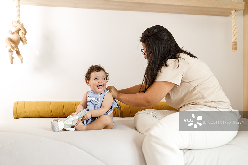 女人给幼儿换衣服图片素材