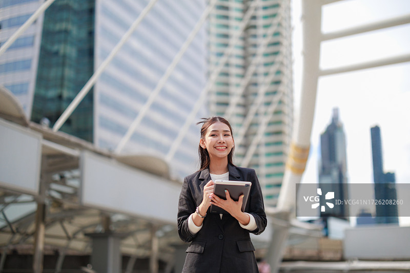 在曼谷办公室中心用平板电脑制定战略的自信的亚洲女商人图片素材