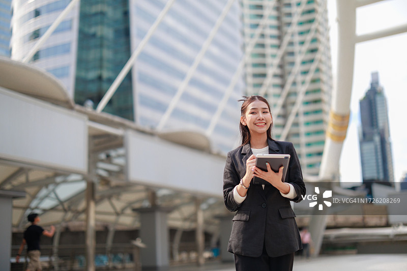 在曼谷办公室中心用平板电脑制定战略的自信的亚洲女商人图片素材