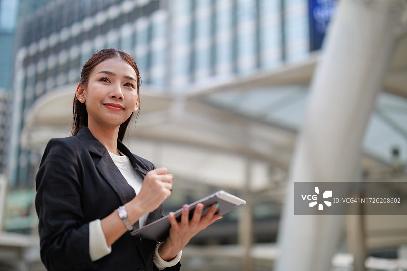 在曼谷办公室中心用平板电脑制定战略的自信的亚洲女商人图片素材