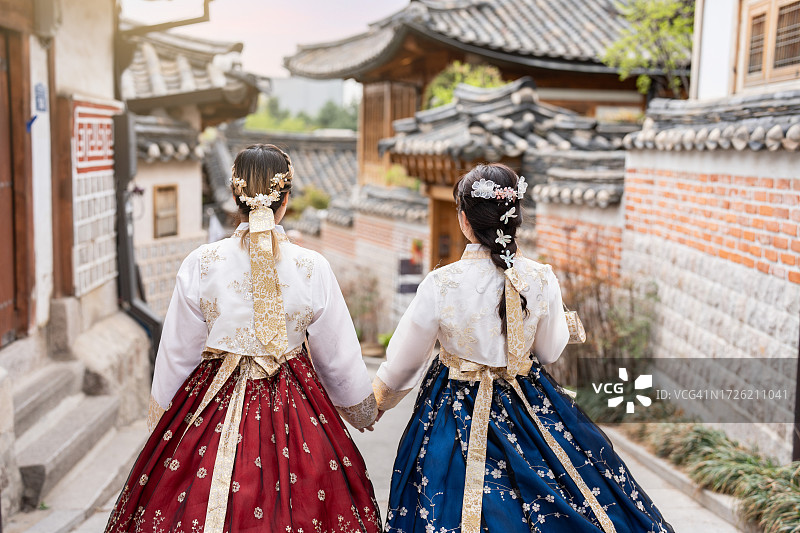 两位穿着韩服的漂亮女人漫步在首尔北村韩屋村图片素材