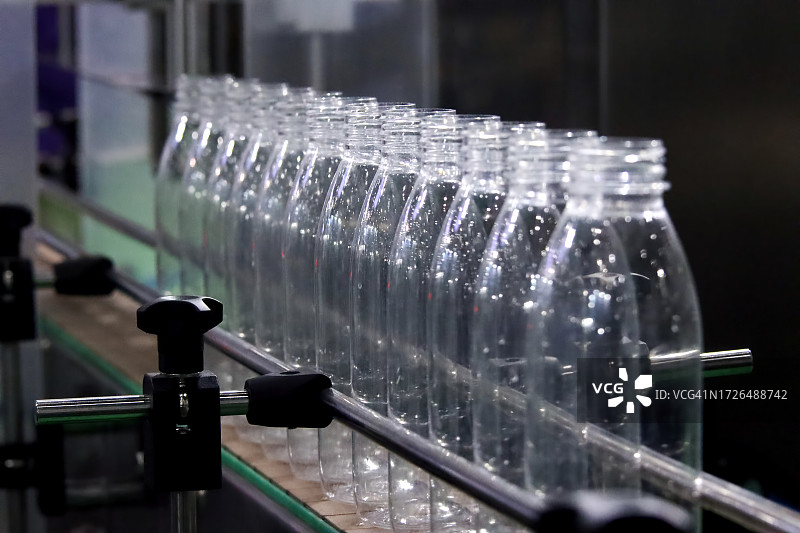 饮用水厂灌装线上空置的瓶子，塑料瓶制造高科技工艺图片素材