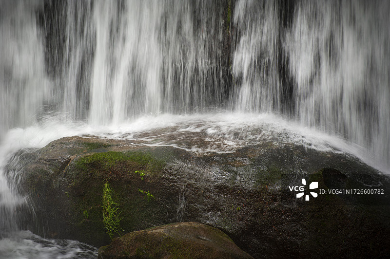 瀑布飞溅于巨石上的特写图片素材
