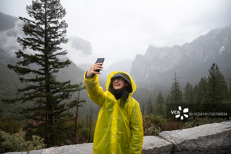 身穿黄色雨衣的女子在加利福尼亚州优胜美地国家公园图片素材