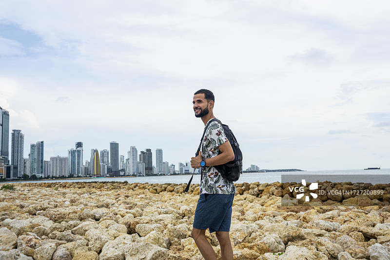 在哥伦比亚卡塔赫纳博卡格兰德海滩漫步的西班牙裔男游客图片素材