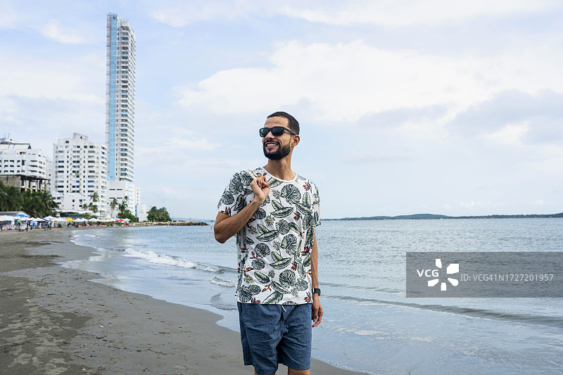 在哥伦比亚卡塔赫纳博卡格兰德海滩散步的西班牙裔男人图片素材