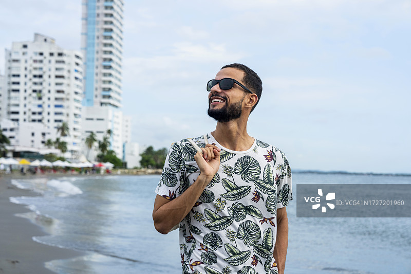 在哥伦比亚卡塔赫纳博卡格兰德海滩欣赏风景的西班牙裔男游客图片素材